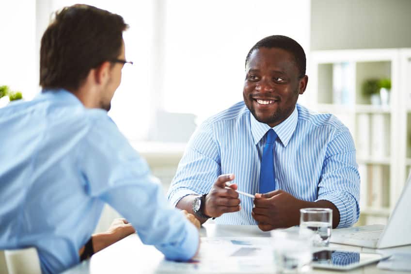 Deux hommes discutent ensembles dans un bureau.