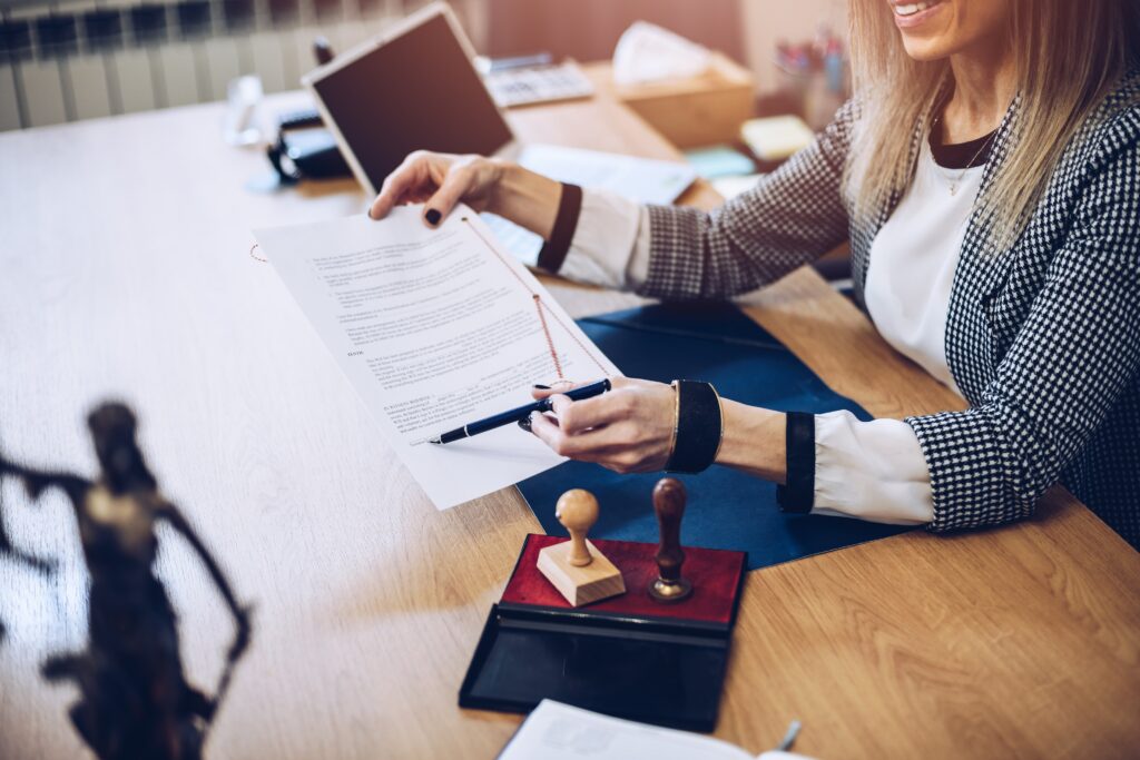 Photo d'une femme à un bureau qui montre une feuille avec un stylo