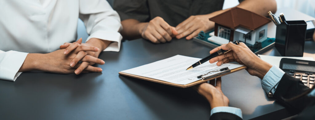 Trois personnes à une table entrain de consulter un contrat