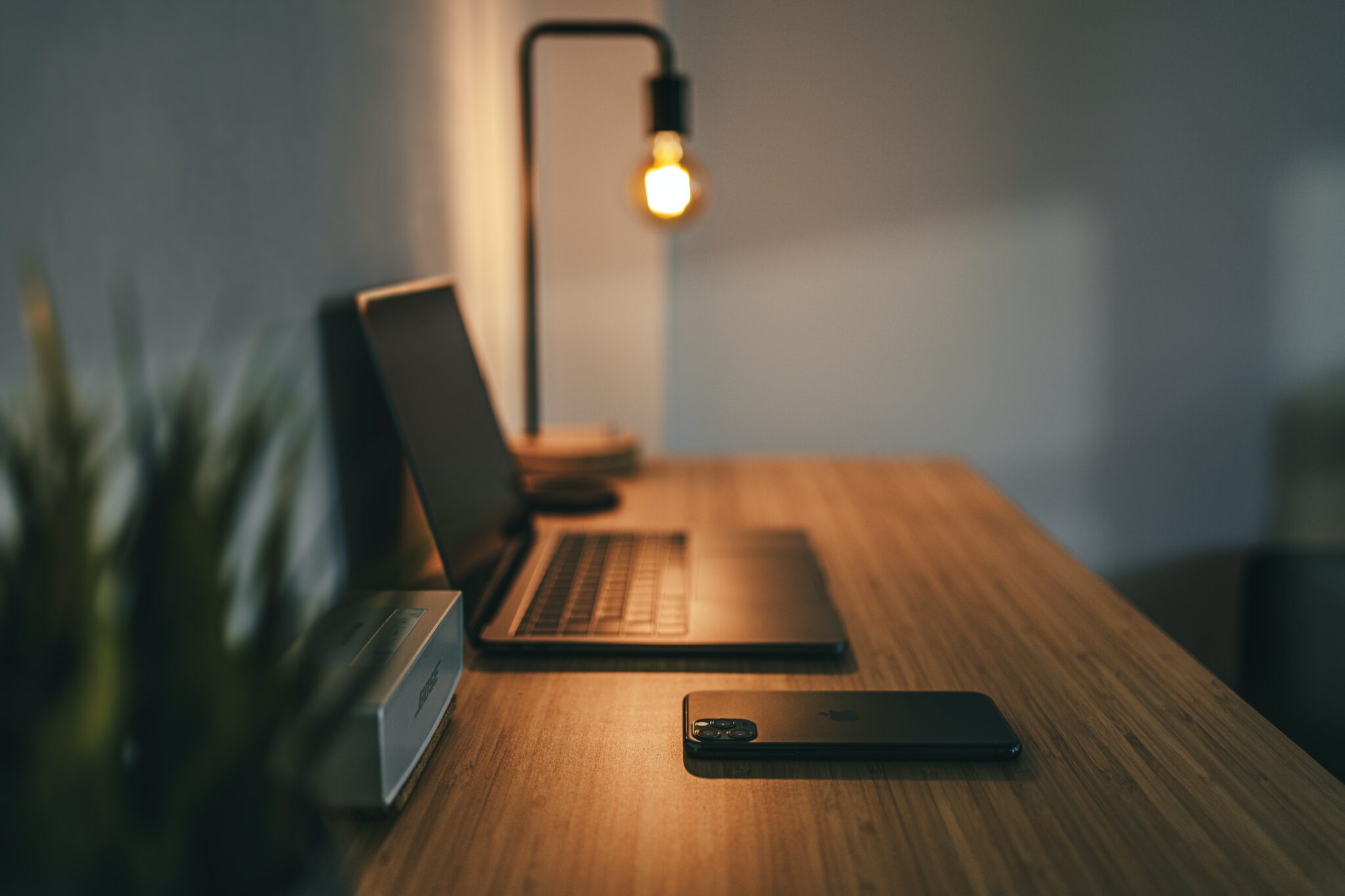 Photo d'un bureau avec une lampe, un ordinateur  et une plante verte