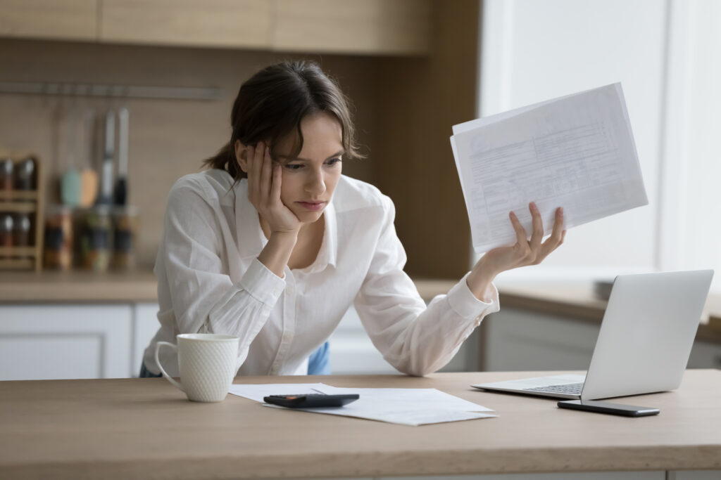 Jeune femme à son bureau avec des papiers dans les mains